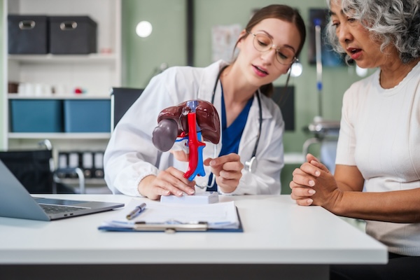 Caucasian woman accompanies an elderly Asian woman dealing with Hepatitis B, cirrhosis, and liver cancer. They seek medical advice and support together. Liver model learning